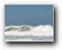 Welle reist Sand hoch  
